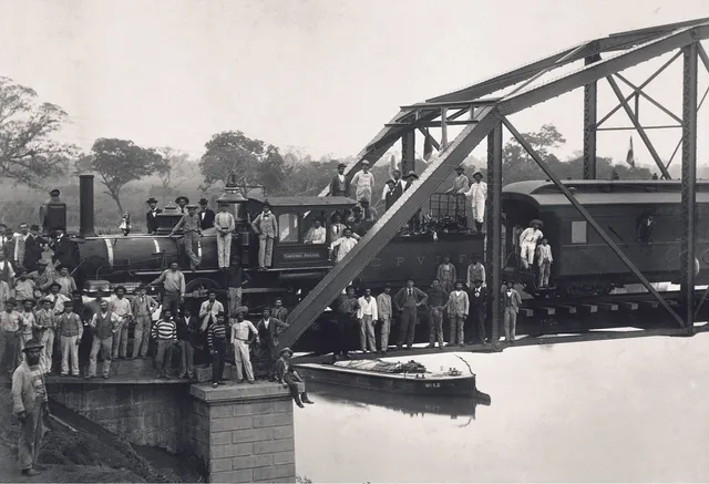 Operários da antiga estação Sorocabana posam em frente a um trem. 