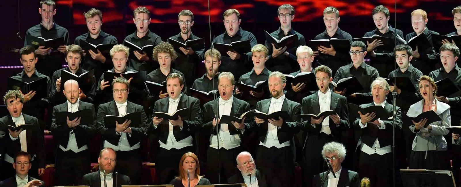 Foto dos músicos do Coral Monteverdi cantando. Todos vestem preto.