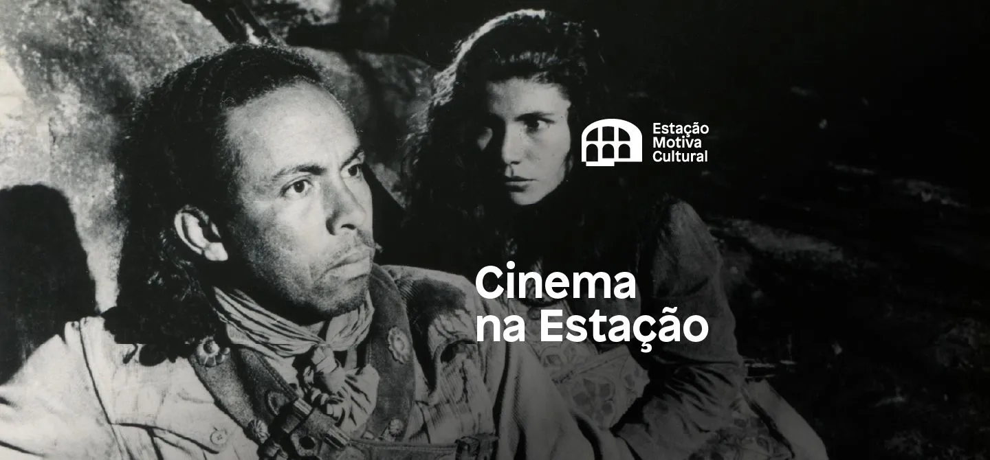 A imagem é uma foto em preto e branco de um cangaceiro e de uma moça.