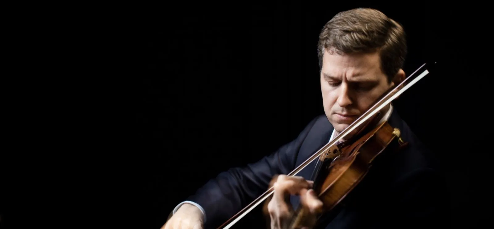 Retrato do violinista James Ehnes, um homem branco de cabelo castanho, tocando violino
