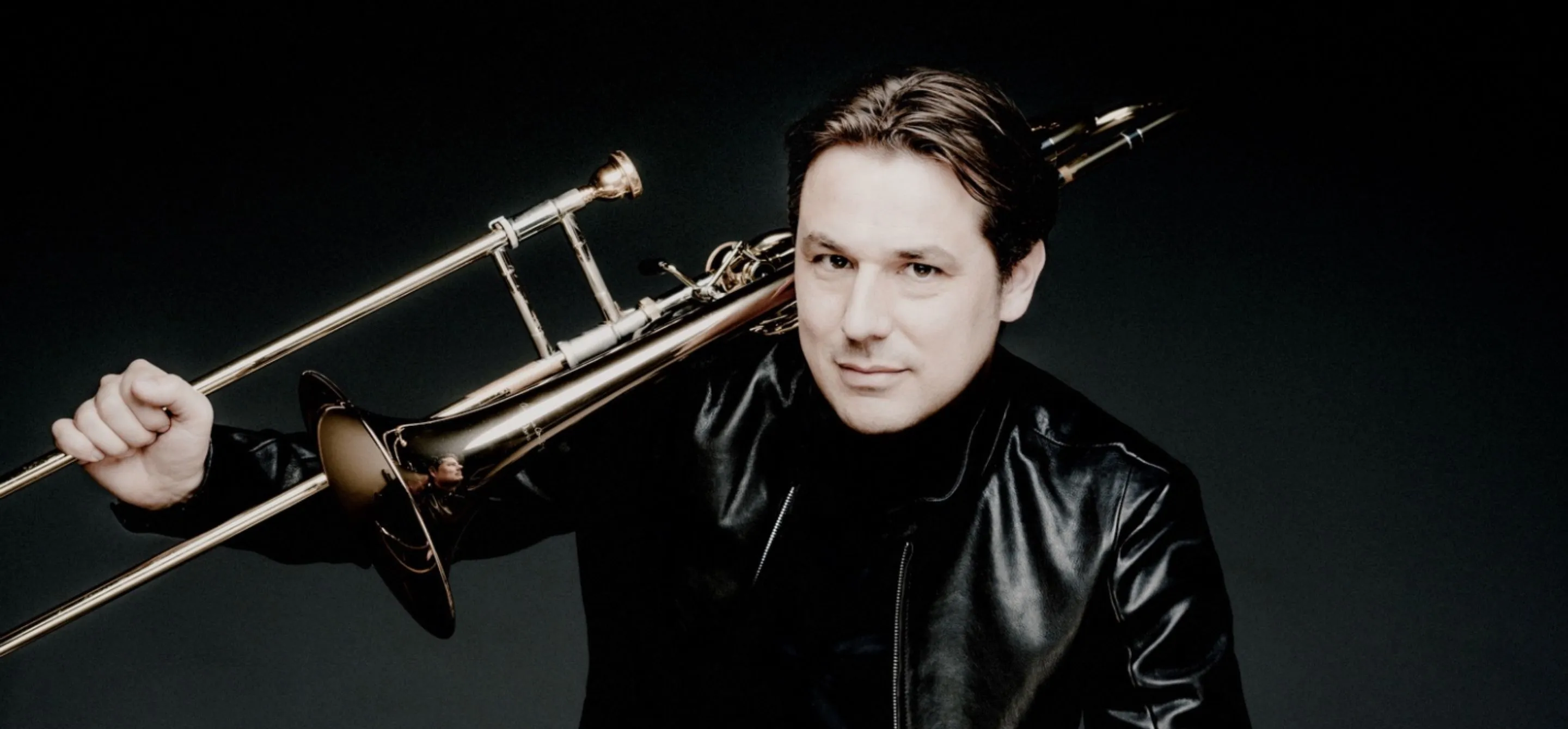 Retrato de Jörgen van Rijen, um homem branco de cabelo preto, segurando seu trombone