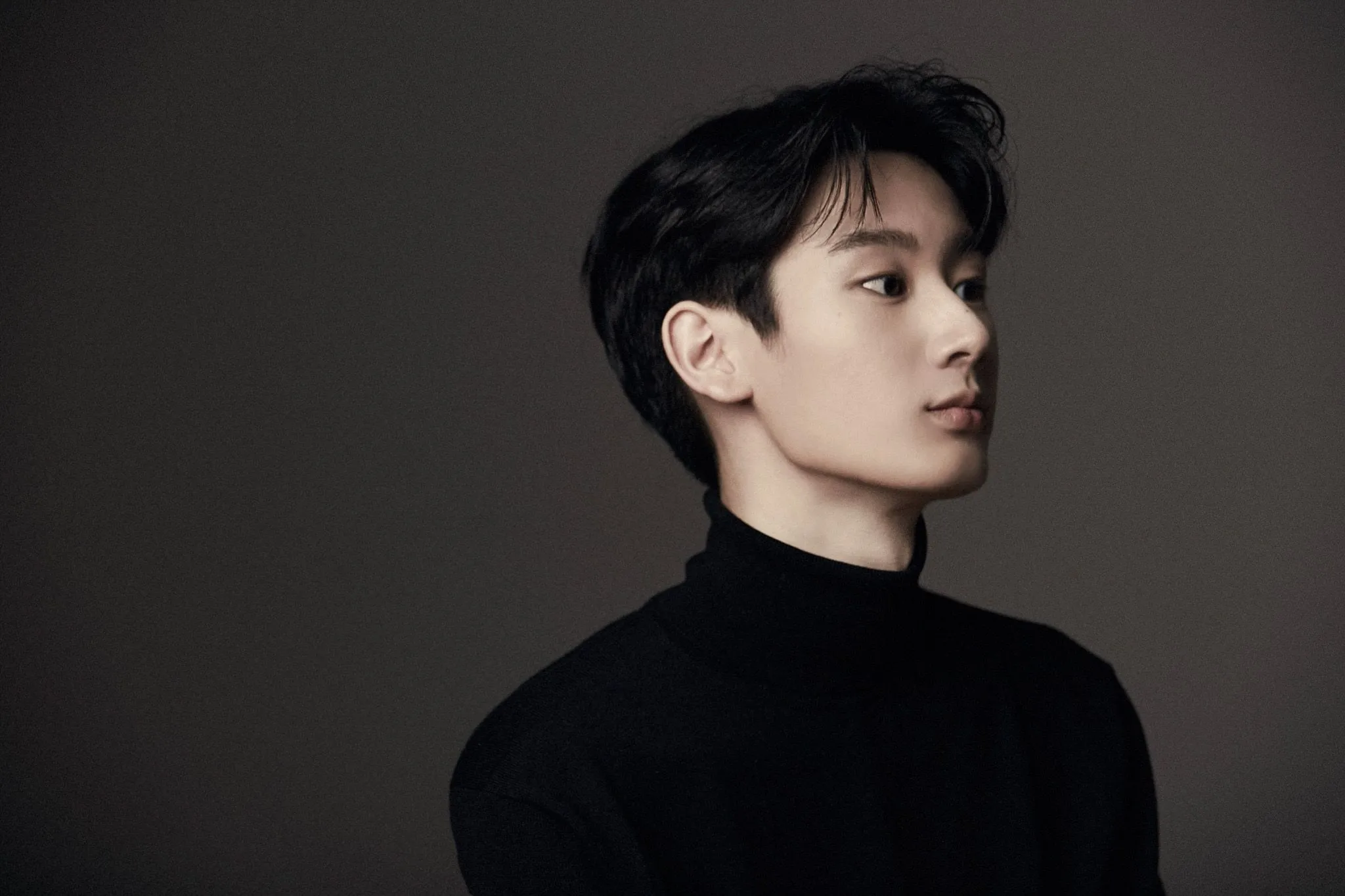 Sunmin Kim, um homem vestindo preto em um fundo infitino.